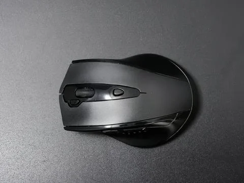 Wireless computer mouse on gray surface for office work Stockfoto's