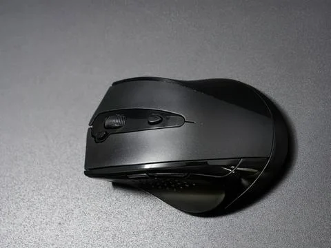 Wireless computer mouse on gray surface with shadow Stock Photos