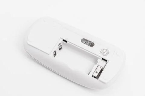 Wireless computer mouse with open battery compartment on white surface Stock Photos