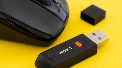 Wireless computer mouse with wifi adapter on yellow background. Stock Photos