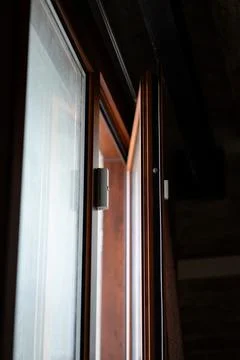 Wireless contact sensor protecting an open wooden window frame Stock Photos
