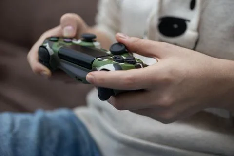Wireless controller joystick in woman's hands, playing video games. Close up Stock Photos
