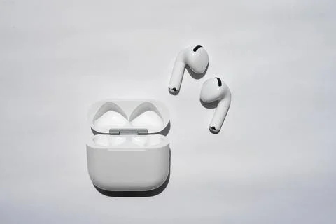 Wireless earbud with floating music note concept on white background Stock Photos
