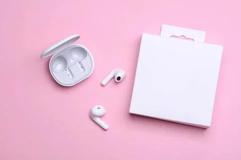 Wireless earbuds with charging case on pink background Stock Photos