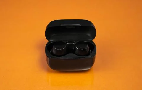 Wireless Earbuds Mockup on Orange for Tech Brands Foto stock