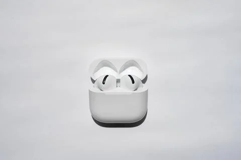 Wireless earbuds in open charging case on white background Stock Photos