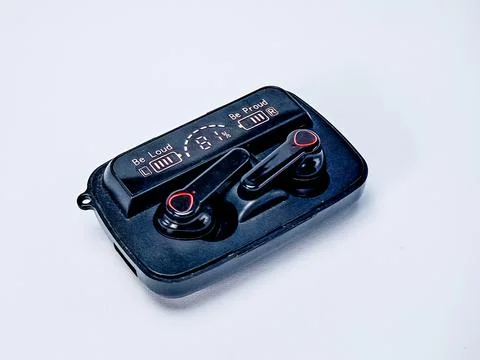 Wireless earbuds rest inside their charging case, displaying battery level .. Stock Photos