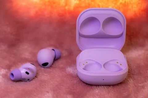 Wireless earpone buds on pink background Stock Photos