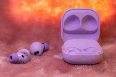 Wireless earpone buds on pink background Stock Photos
