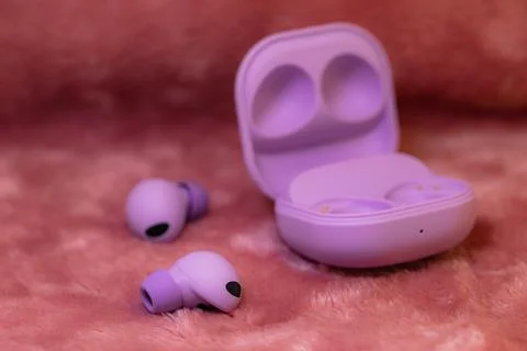 Wireless earpone buds on pink background Stock Photos