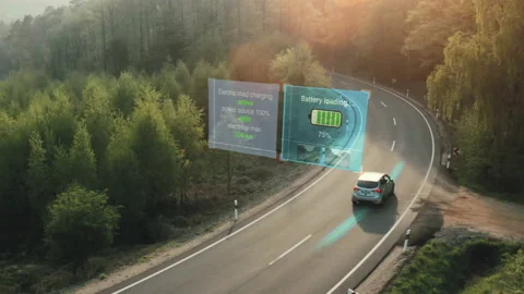 Wireless electric vehicle charging while driving on road charging system Stock Footage 230052414