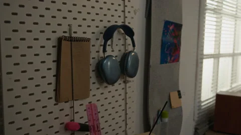 Wireless Headphones with Notebook Hanging on Pegboard in Student Workspace Stock Footage 336619277