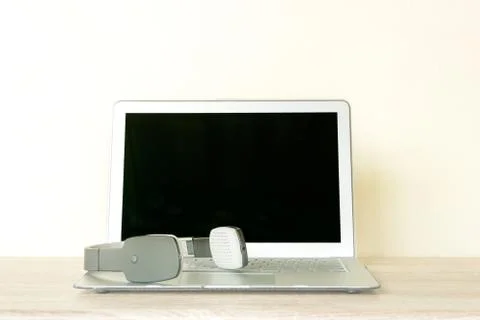 Wireless headset and Computer laptop on wooden table Stock Photos