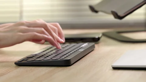 Wireless keyboard and smartphone, hands typing in home office. Stock Footage 316656993