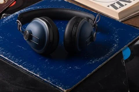 Wireless large blue headphones on a stack of vintage vinyl records next to a  Stock Photos