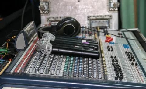 Wireless microphone and headphone put on sound music mixer control panel Stock Photos