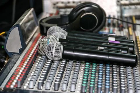 Wireless microphone and headphone put on sound music mixer control panel Stock Photos