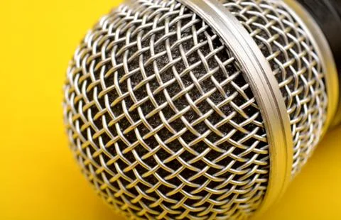 Wireless microphone close up on yellow background - Motivational Speaker concept Stock Photos