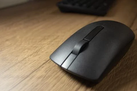 Wireless mouse and keyboard set on top of a wooden office desk, on a workstat Foto stock