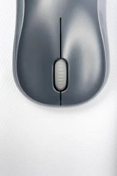 A wireless mouse positioned vertically on the cover of a laptop Stock Photos