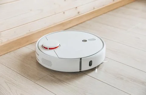 Wireless robot vacuum cleaner working on the floor. Smart household technolog Stock Photos