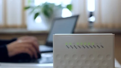 Wireless router. A man uses the Internet on a laptop. Closeup Stock-Footage 102641308
