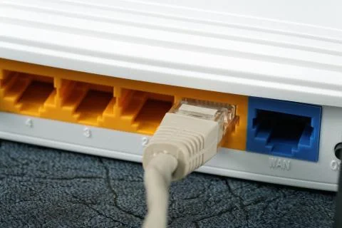 Wireless Routers and Networking Cable on table Stock Photos