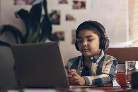 Wireless tech gave us an easier way of learning. an adorable little boy using a Stock Photos