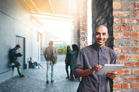 Wireless tech, less books, more learning. a young man using a digital tablet Stock Photos