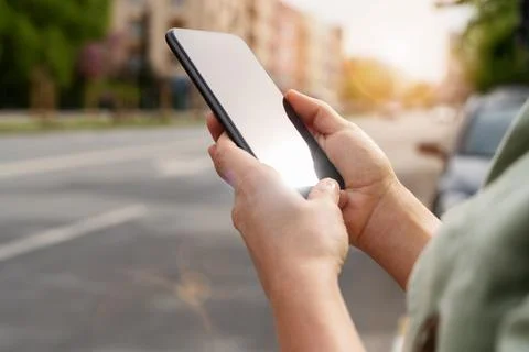 Wireless technology in city. Close-up screen of smartphone in woman's hands o Stock Photos
