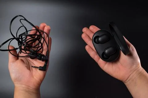 Wireless vs wired headphones. Bluetooth headphones. Stock Photos
