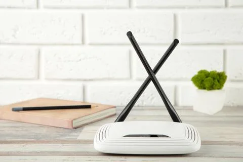 Wireless Wi-Fi router on white background with notebook Stock Photos