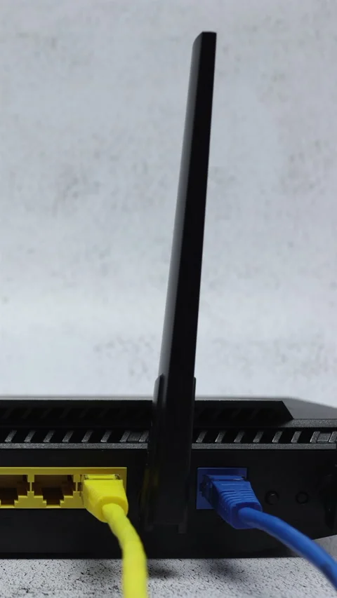 Wireless WIFI Router With Blue Patch Cord In WAN Connector And Yellow Patch Cord Stock Footage 267869484