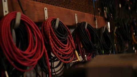 Wires and cables for musical instruments hang on the wall in an analog recording Stock-Footage 218363320