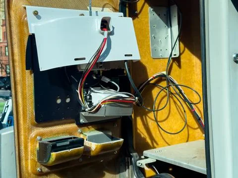 Wires and components inside a service vehicle near a city street during day.. Stock Photos