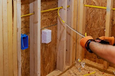 Wires are connected to socket boxes during construction of a new building by an Stock Photos