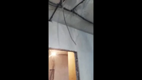 Wiring installation in a room with exposed electrical cables on the wall at a co Stock Footage 326119795