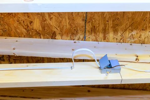 Wiring setup for electrical outlet under wooden beams in construction site Stock Photos