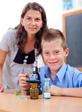 Wise boy with microscope and teacher Stock Photos