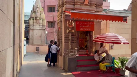 A wise pandit guides two foreigners at a holy temple in Varanasi Stock Footage 284495431