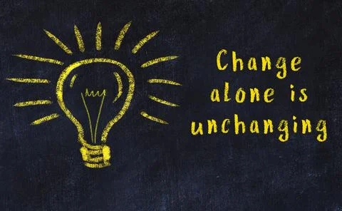 Wise quotation and a chalk drawing of a bulb on black chalkboard 스톡 사진