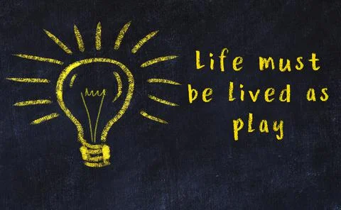 Wise quotation and a chalk drawing of a bulb on black chalkboard 库存照片