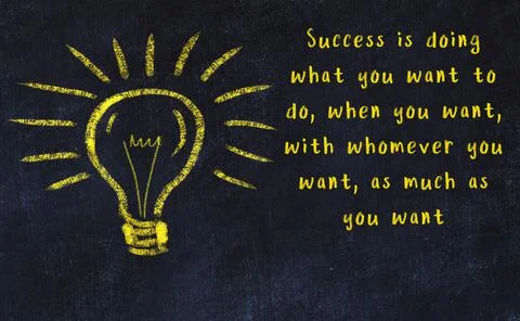 Wise quotation and a chalk drawing of a bulb on black chalkboard 库存照片