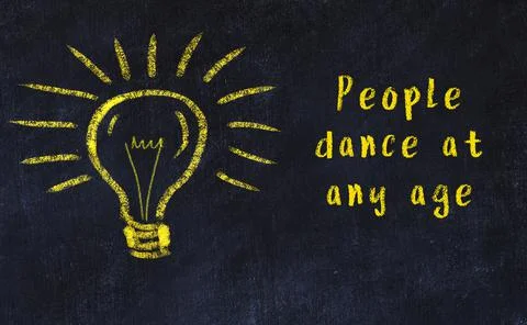 Wise quotation and a chalk drawing of a bulb on black chalkboard 库存照片