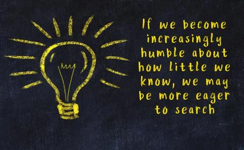 Wise quotation and a chalk drawing of a bulb on black chalkboard 库存照片
