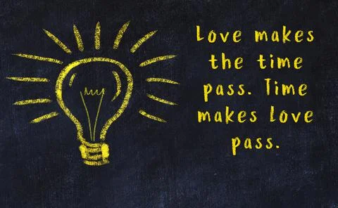 Wise quotation and a chalk drawing of a bulb on black chalkboard Photos