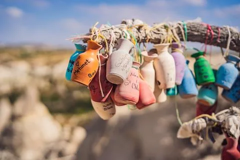 Wish tree. Small multi-colored jugs with inscriptions, wishes hanging on the 库存照片