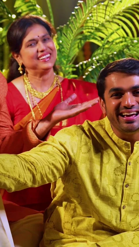 Wishing happy Diwali to camera while Indian family sits indoors with diya Stock Footage 342345932