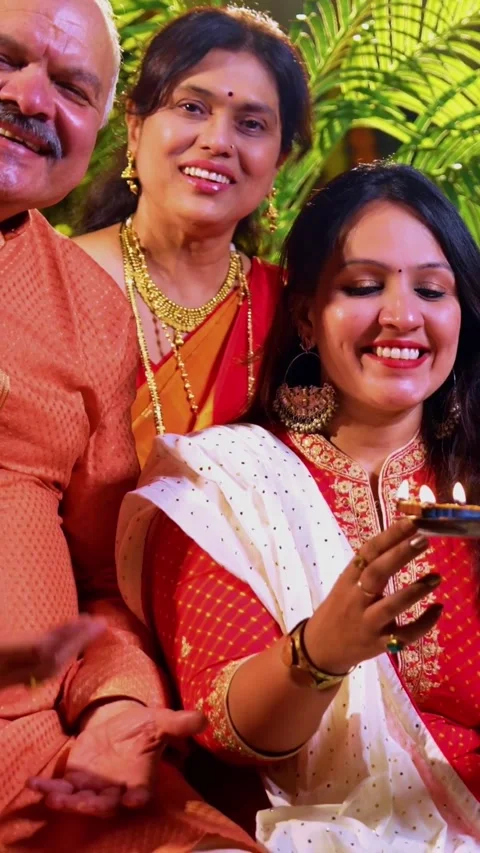 Wishing happy Diwali to camera while Indian family sits indoors with diya Video stock 342345933