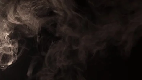 Wisps of smoke gracefully swirl and dance against a dark background Stock Footage 340264491